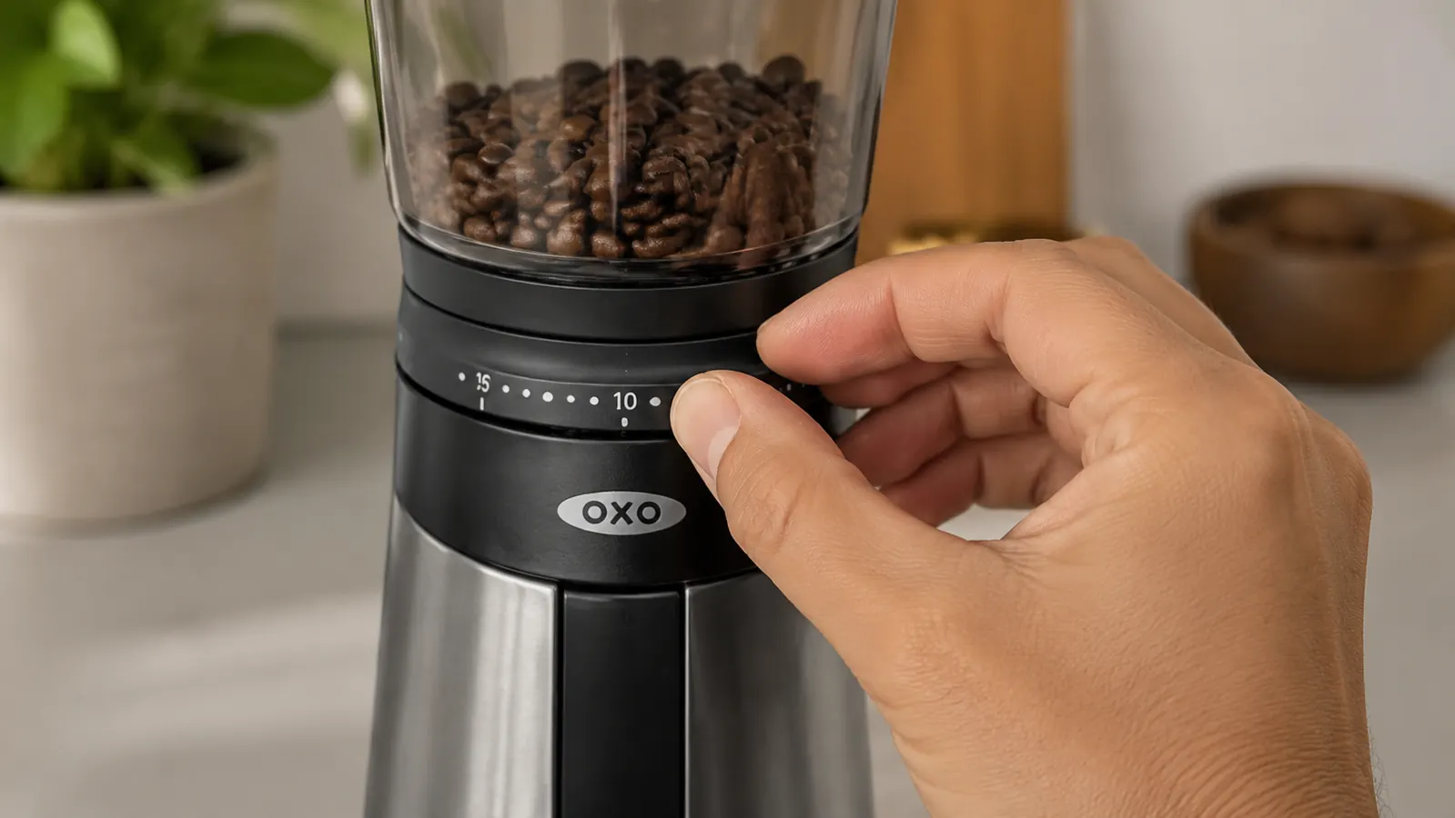 Hand adjusting the grind size dial on the OXO Brew Conical Burr Grinder