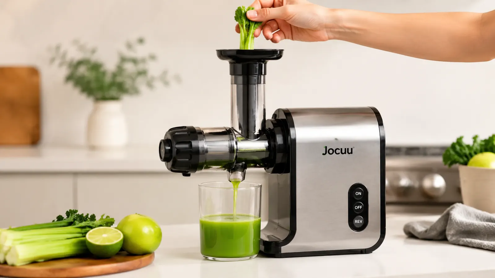 Hand feeding a stalk of celery into the Jocuu masticating juicer with fresh juice flowing into a glass below